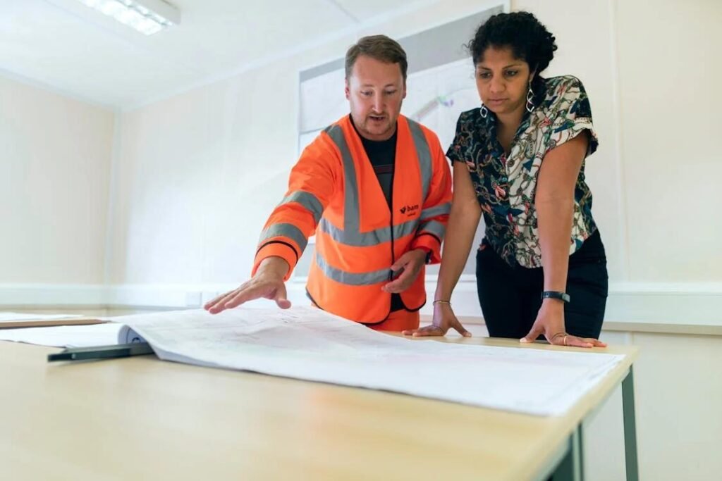 Construction professional reviewing blueprints with a woman during the planning stage of a custom home build in Santa Barbara.