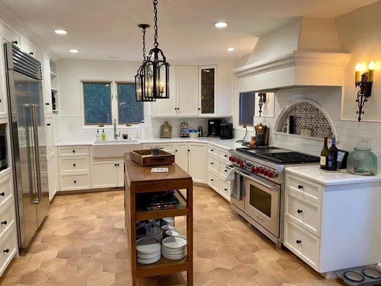 Custom kitchen remodel in Santa Barbara featuring white cabinetry, detailed millwork, premium appliances, and a central work island.